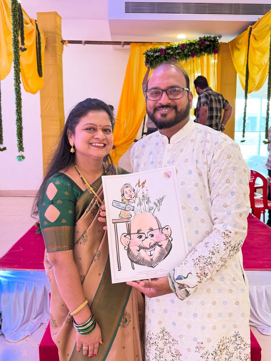 Couple at a haldi ceremony holding a live caricature of the groom with bottle prop